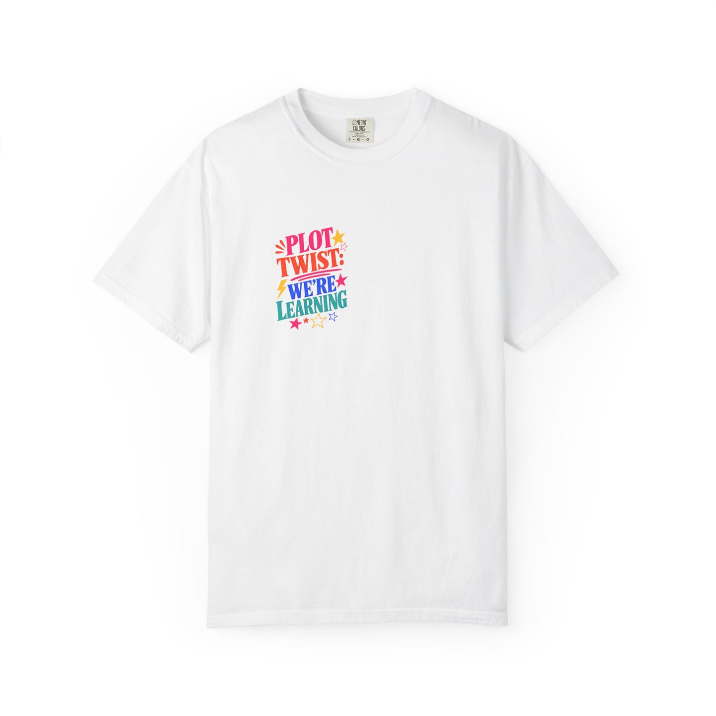 Plot Twist: We're Learning Tee in White, front view - a small left-chest print on a garment-dyed Comfort Colors 1717 tee.