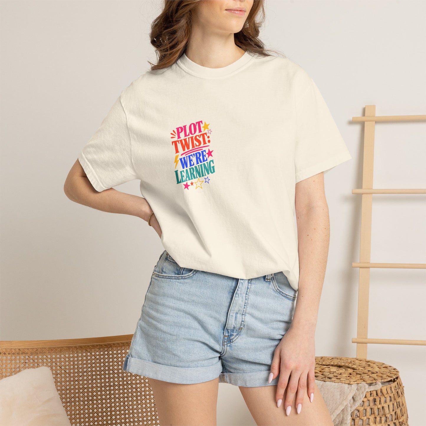 Plot Twist: We're Learning Tee in Ivory, worn by a model - a small left-chest print on a garment-dyed Comfort Colors 1717 tee.